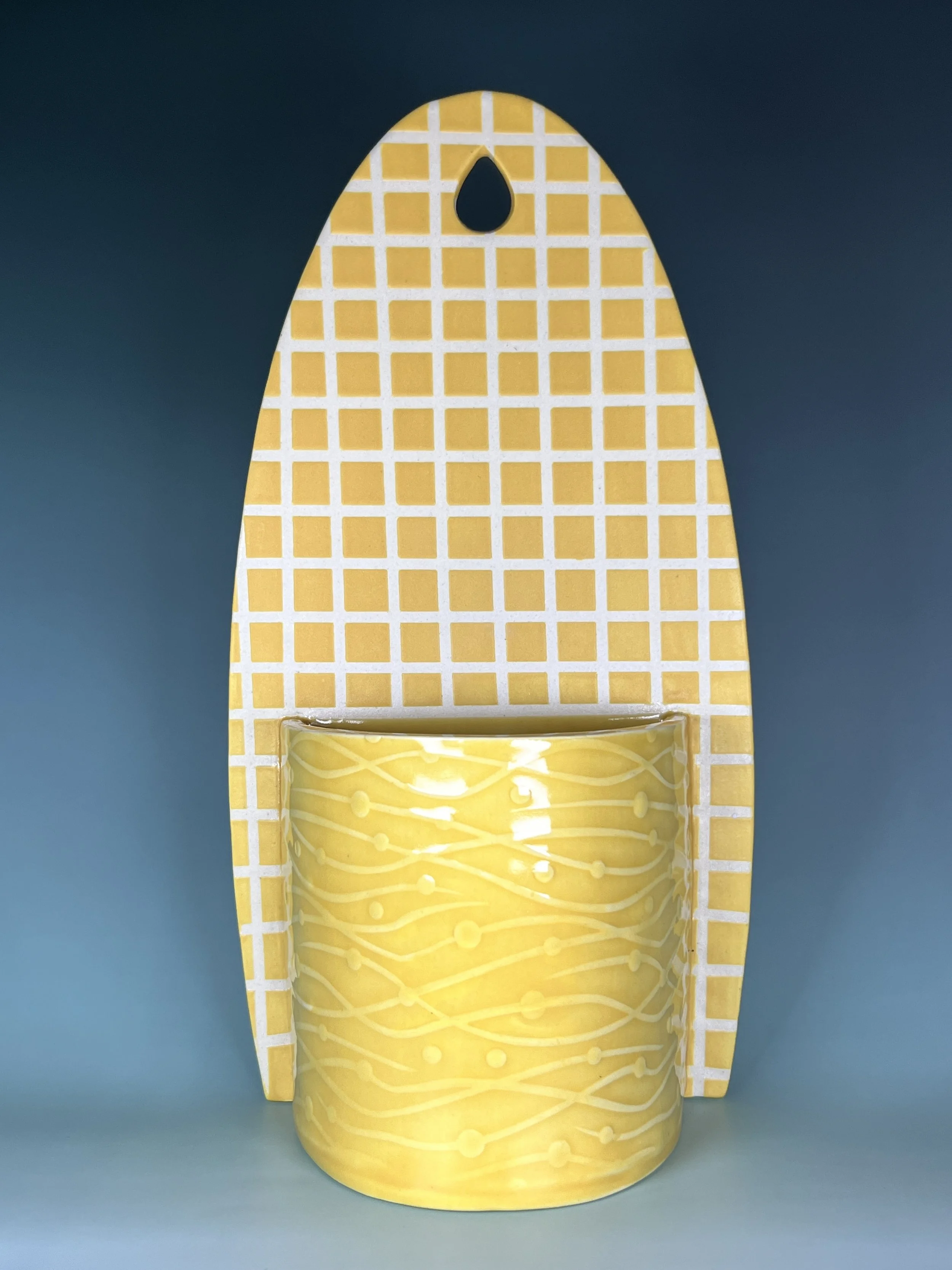 Ceramic wall pocket with a yellow grid