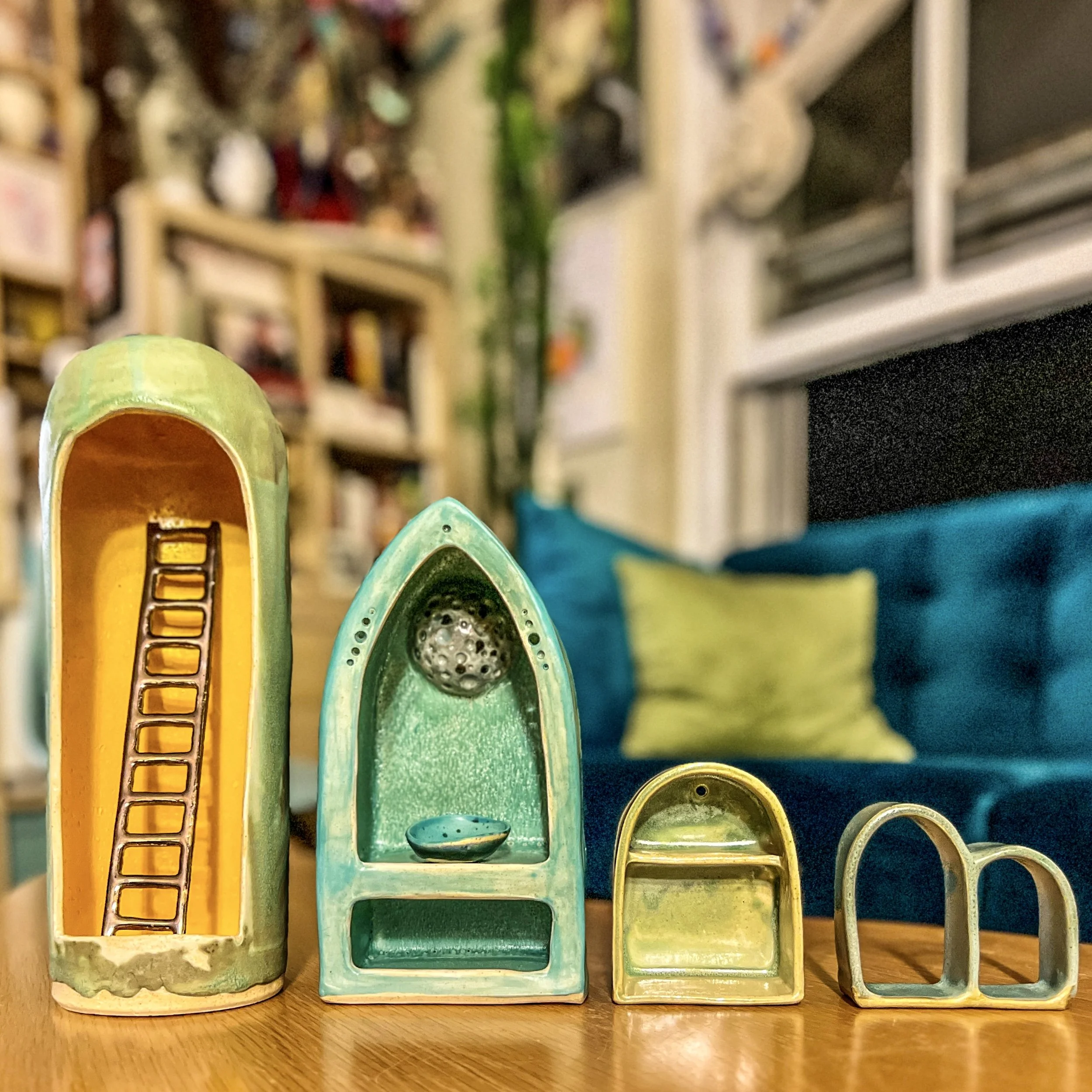  a set of four shrines, the one on the left is tall with around the top with a cold ladder. Inside, the next one has a pointed top with the moon in the back, the next one is small with a curved shape, and the one on the right, it's too small curb sha