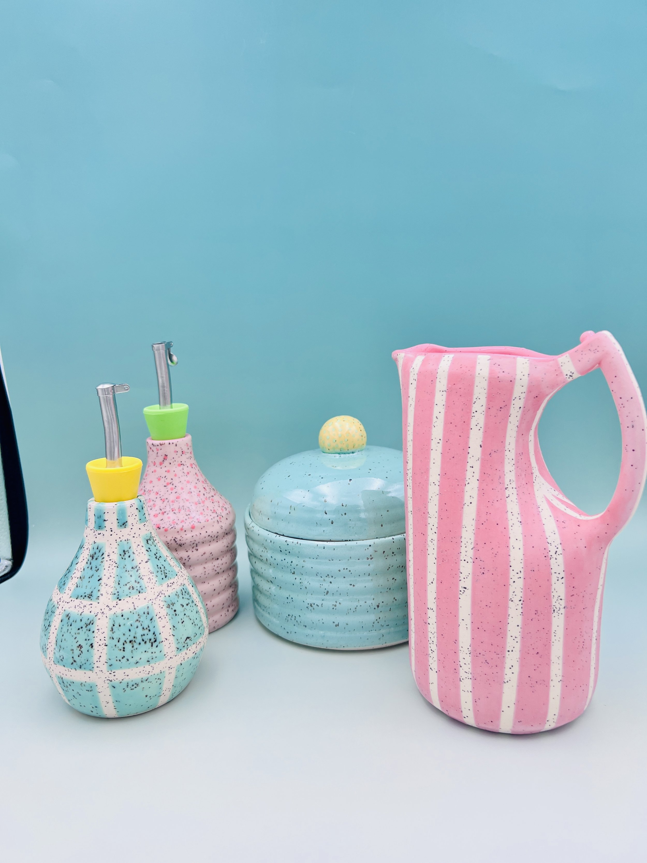 ceramic kitchen gadgets, two oil cruets, a litter jar, a pitcher