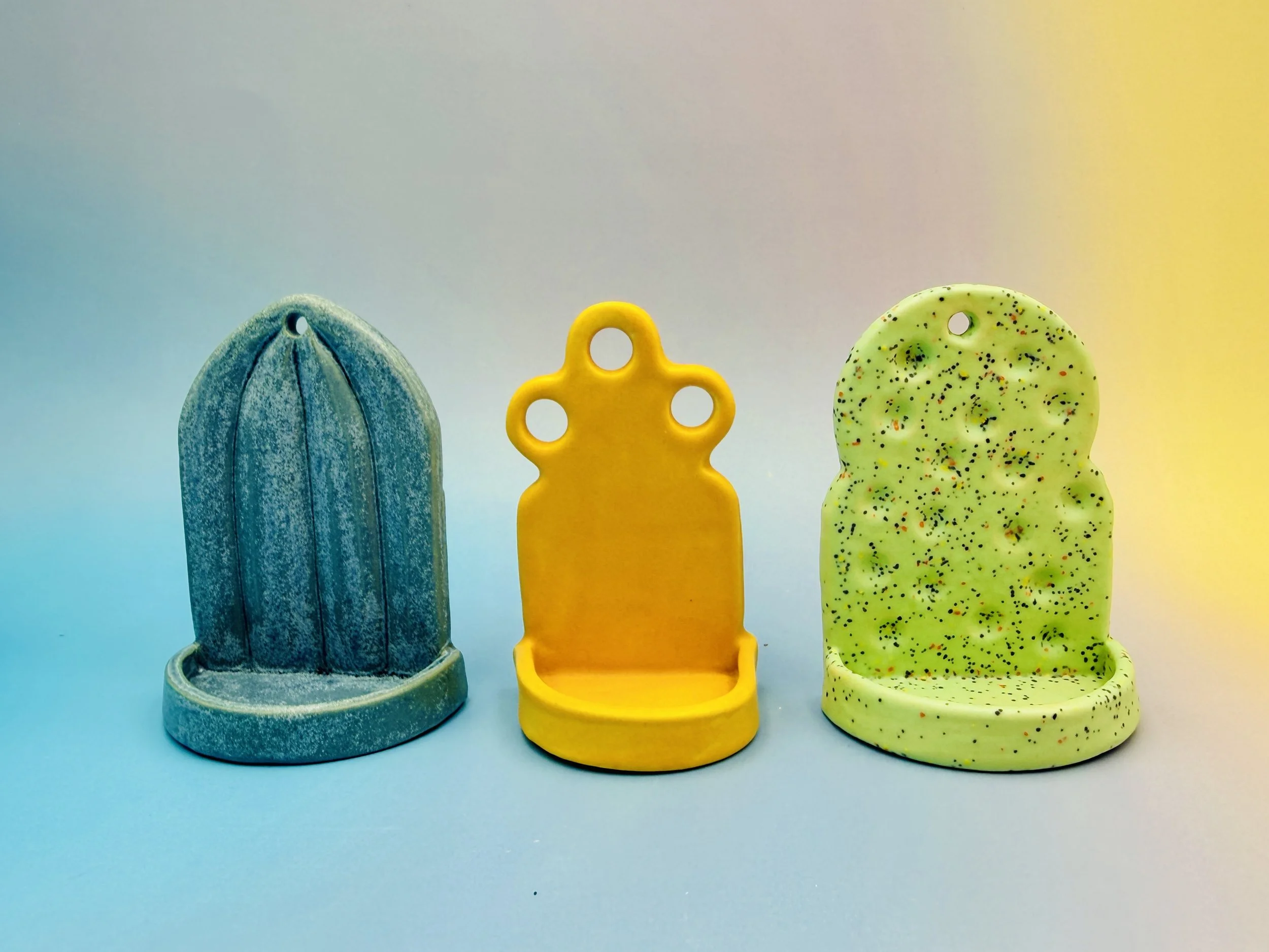  three small shrines the left one is blue, the right one is green and the middle is yellow