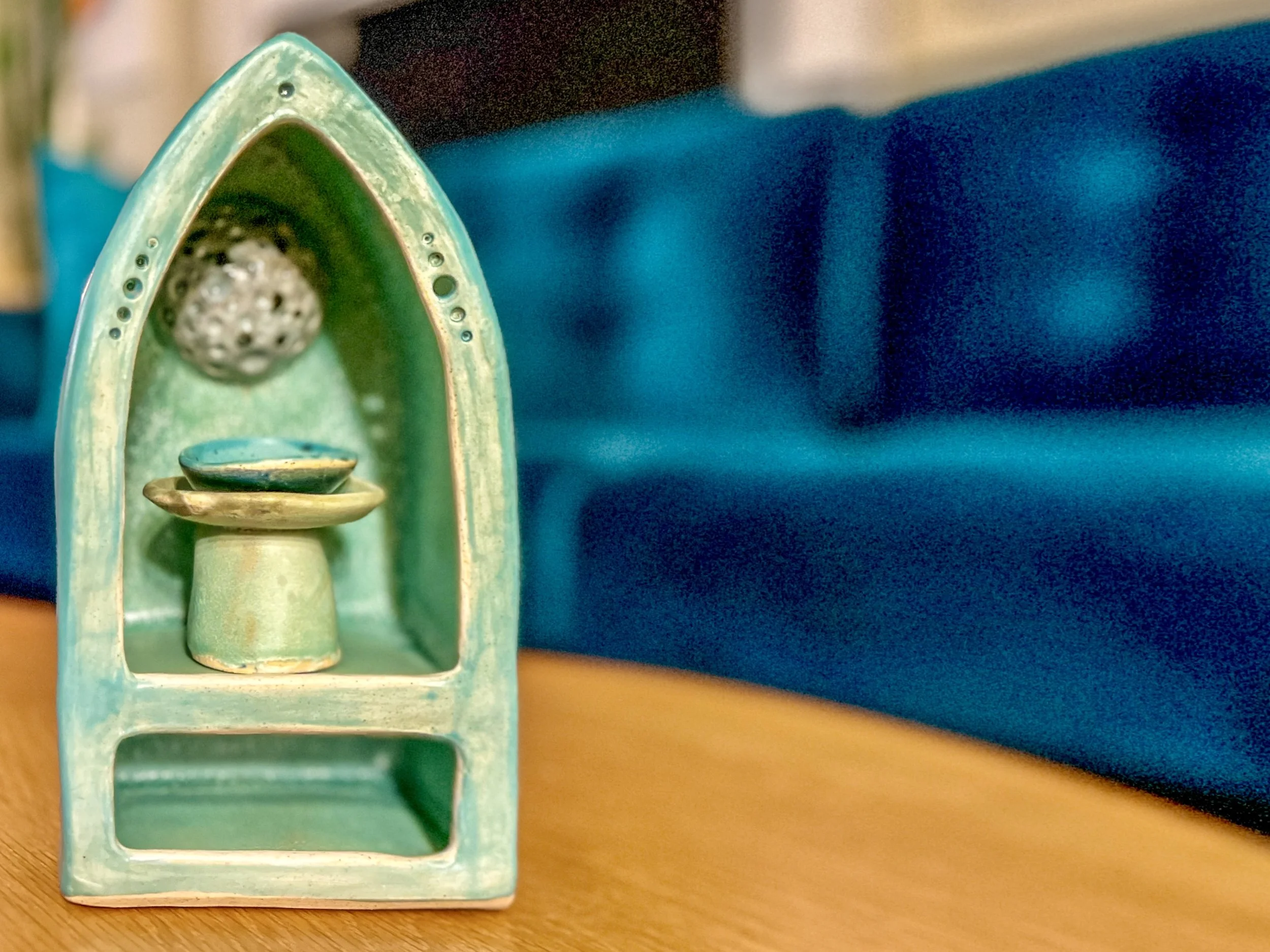  shrine with a pointed top and a moon in the back with a little tray in the middle