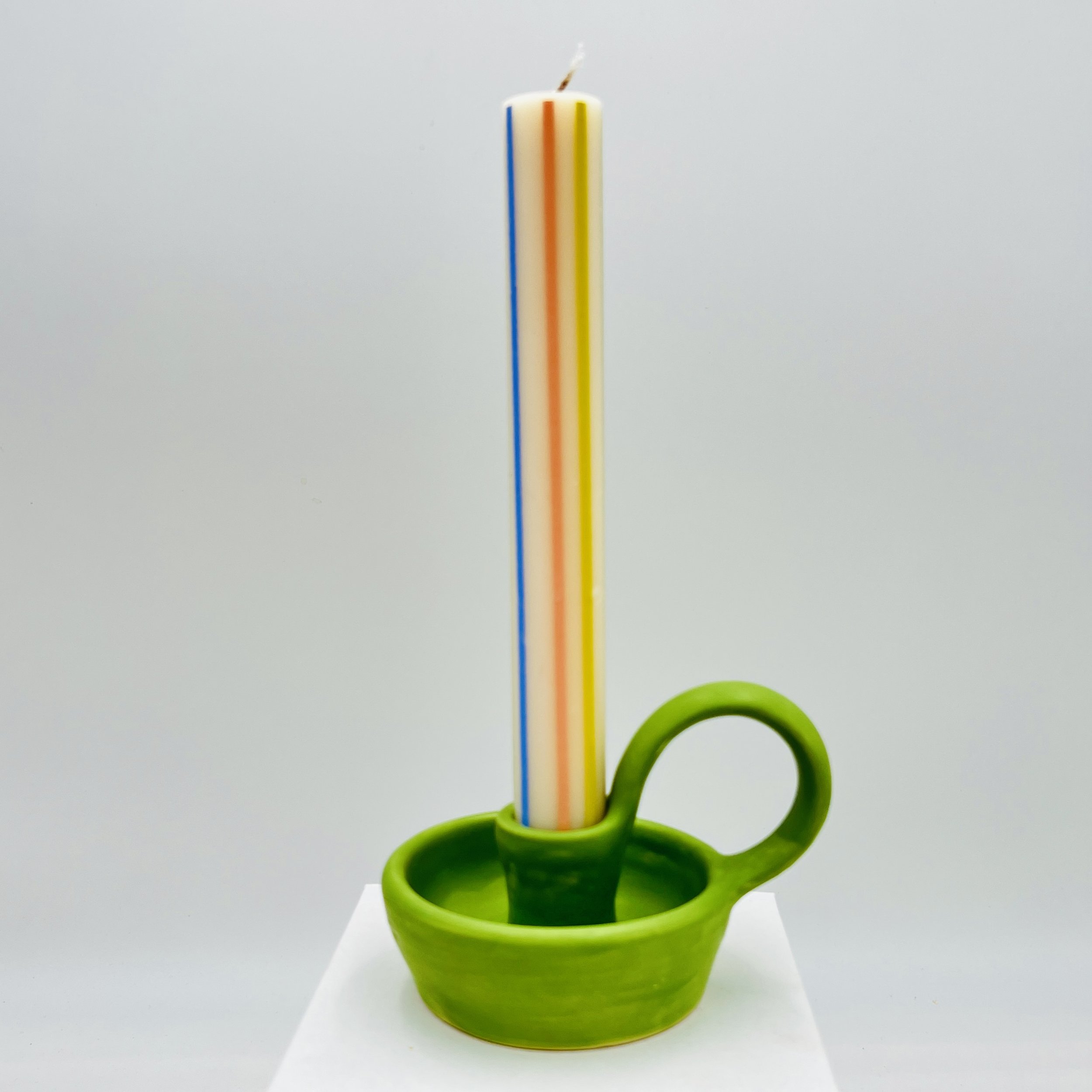  ceramic camel stick holder with a colorful striped candle in it