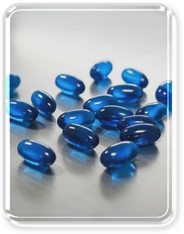 A collection of blue gel capsules scattered on a gray surface.