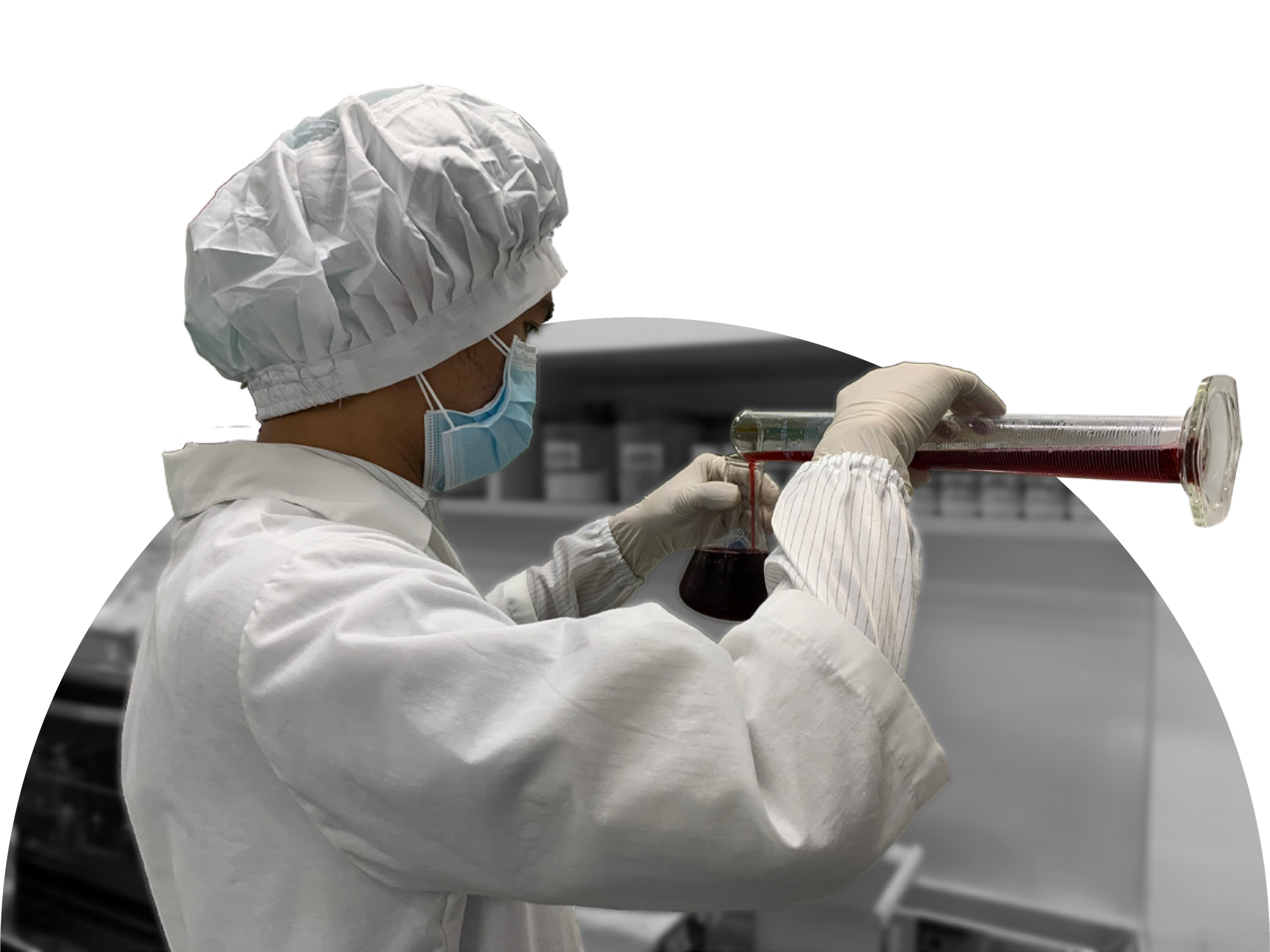 A scientist in protective gear, including a white cap, face mask, and gloves, working with a test tube containing a red liquid in a laboratory.