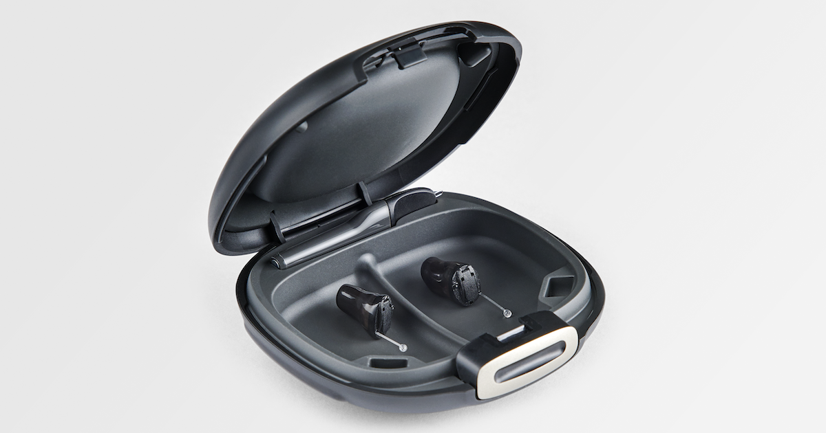 Wireless earbuds in charging case with open lid on a white background.