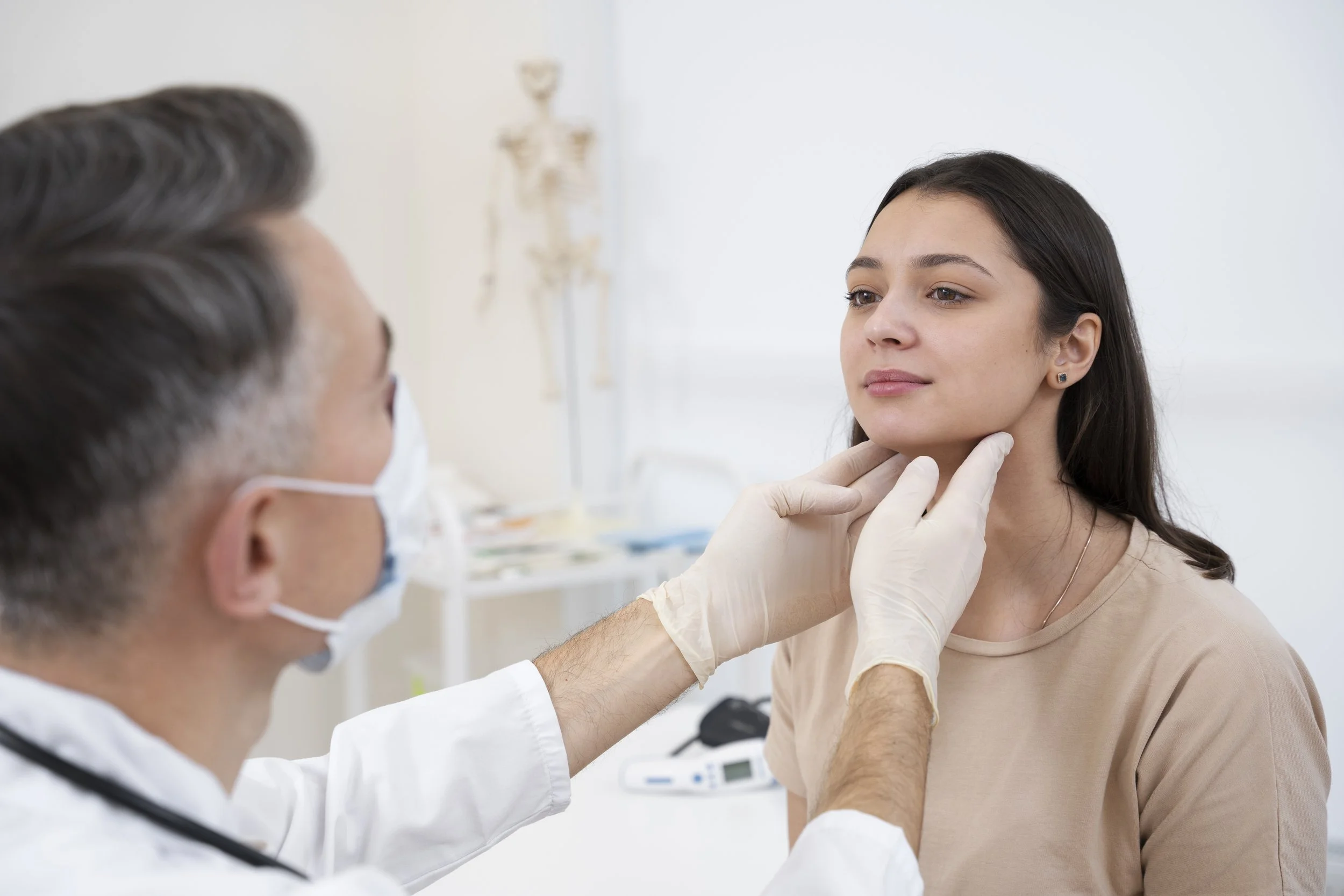 A healthcare professional examines a young woman’s throat in a clinical setting.