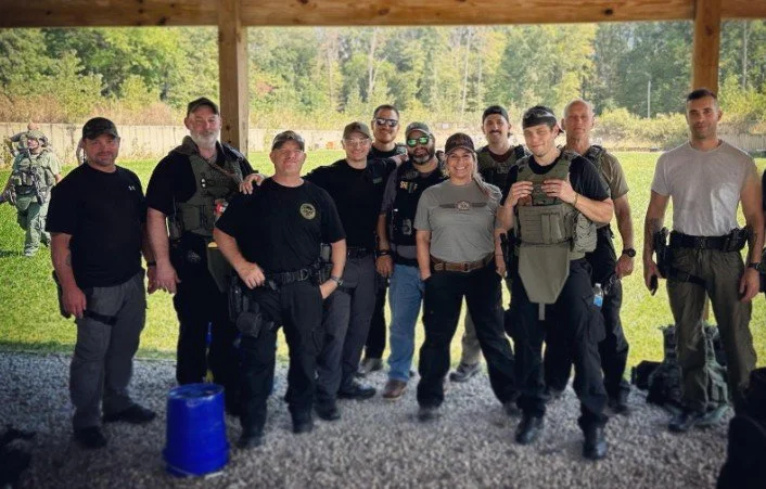 Swat team in tactical gear on shooting range pictured with empowerment expert dr. alice atalanta, who coaches them through her sofxle program which brings military special operations mindset and training to law enforcement community