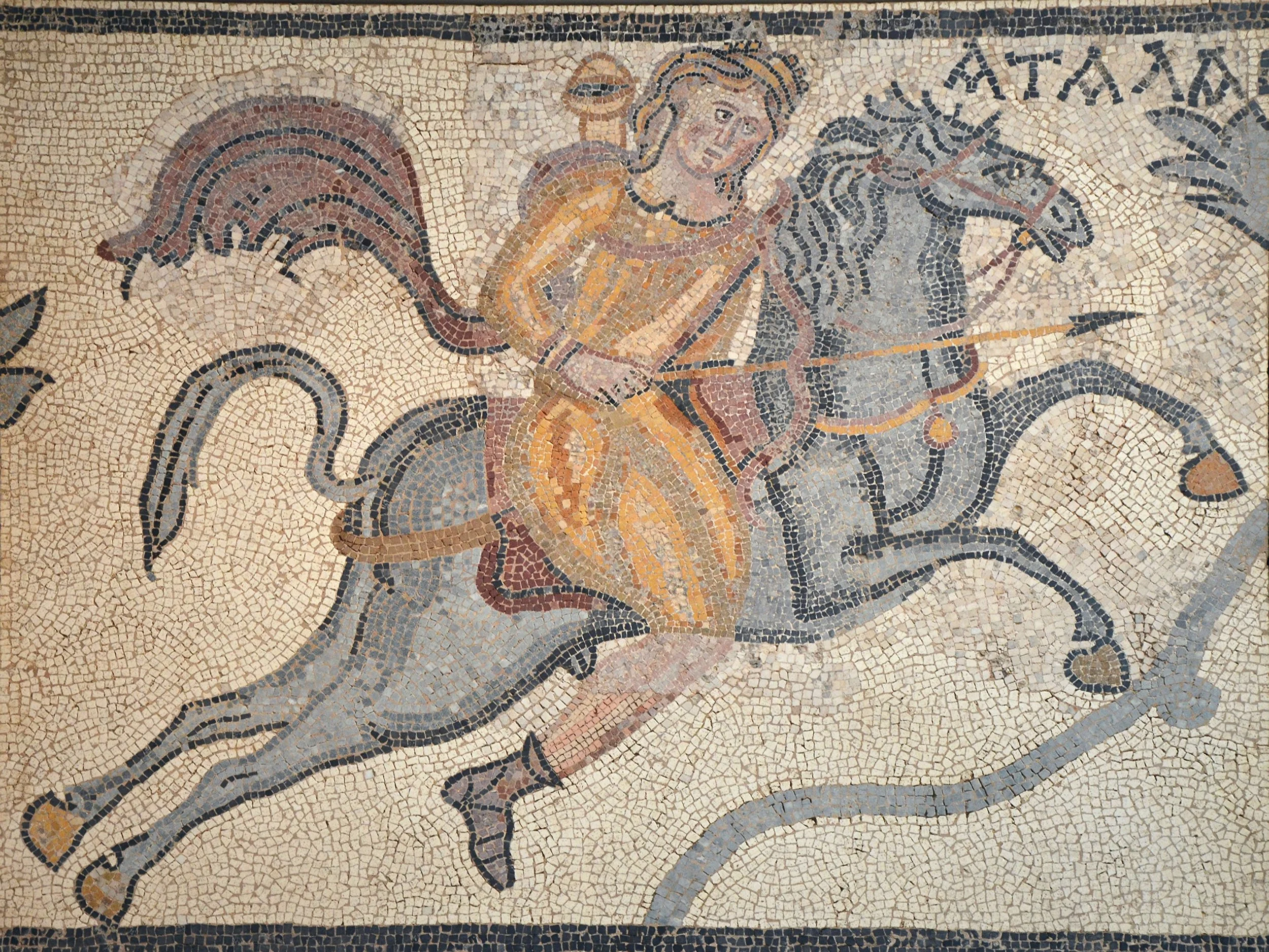 Ancient mosaic depicting the mythical goddess Atalanta riding a horse, holding a spear, with flowing attire and a vibrant pattern.