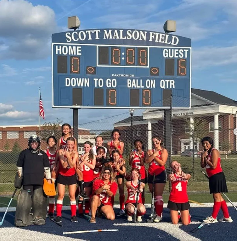 Women's empowerment expert dr. alice atalanta pictured with the field hockey team she coaches as they celebrate a 6-0 win feeling empowered, joyful, confident, powerful, and athletic.
