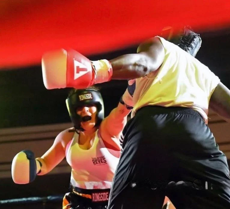 Women's empowerment expert Dr. Alice Atalanta in the boxing ring competing as a USA boxing Athlete against a transgender opponent feeling strong, bold, and powerful.