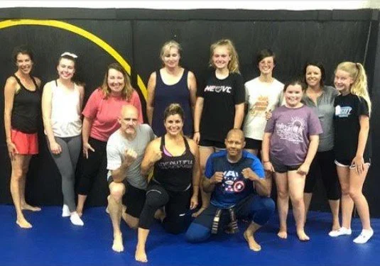 Women's empowerment expert Dr. Alice Atalanta pictured at Revolution Fight & Fitness in Euclid Ohio after a women's empowerment boxing and self-defense seminar with a group of women feeling strong and empowered