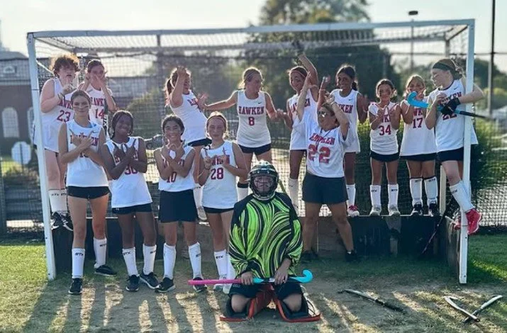 Women's empowerment expert dr. alice atalanta pictured with the field hockey team she coaches as they celebrate a win feeling empowered, joyful, confident, powerful, and athletic.