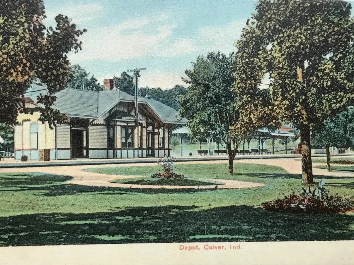 Vintage postcard of a park in Culver, Indiana, featuring a historic train depot building, trees, pathways, and benches.