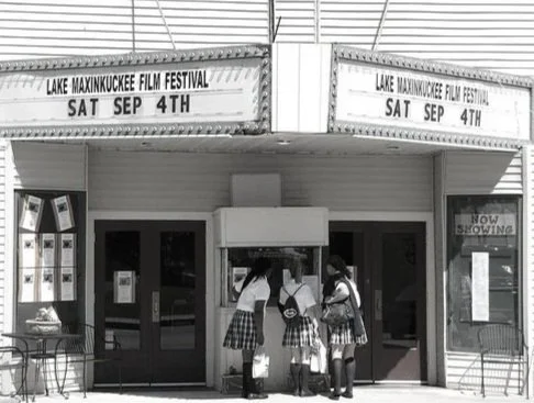Three students in uniform standing outside the theater entrance of the Lake Maxinkuckee Film Festival on September 4th.