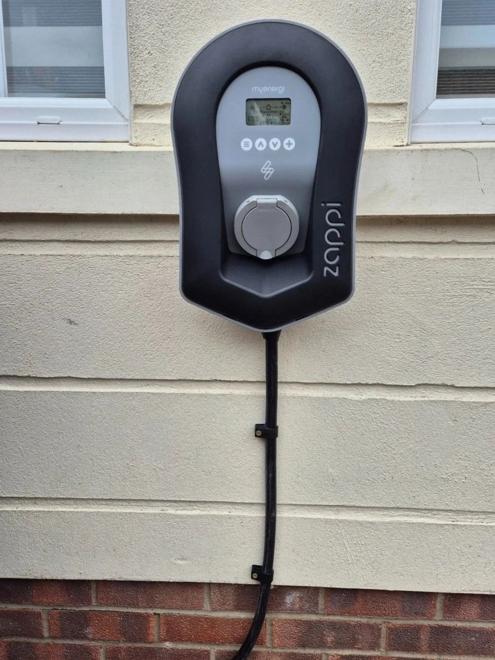 Zappi EV charging station mounted on the exterior wall of a house.
