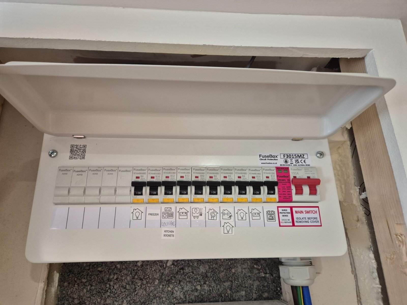 Electrical fuse box with labeled circuit breakers and main switch.