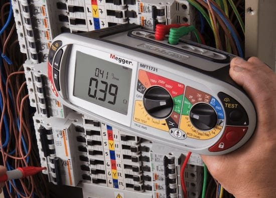 megger multimeter testing electrical wiring inside an electrical panel.