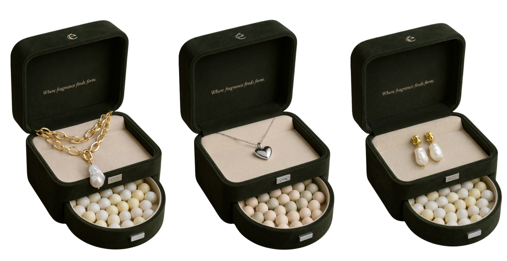 Three jewelry gift boxes each containing a different piece of jewelry. The first box has a gold chain necklace with a large pearl pendant. The second box has a silver heart-shaped pendant necklace. The third box has a pair of pearl earrings with gold accents. All boxes are open, with a black exterior and cream interior, and filled with white and cream-colored packing beads. The inside lid of each box has the phrase, 'Where fragrance finds form.'