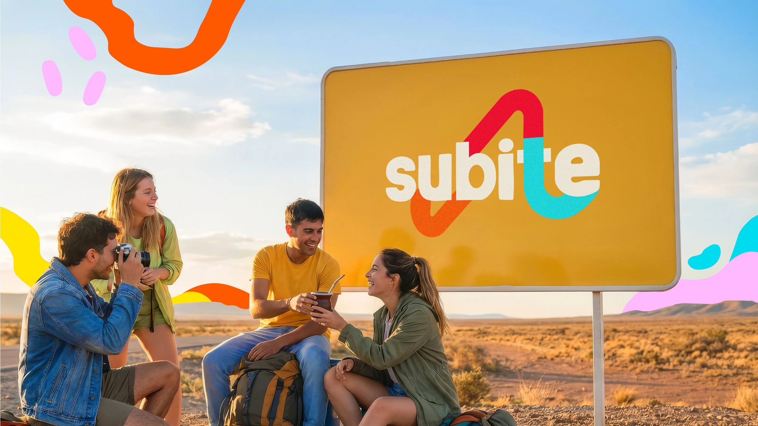 Group of five young adults sitting and standing outdoors in front of a large yellow sign with the Subite logo, enjoying each other's company during sunset in a desert landscape.