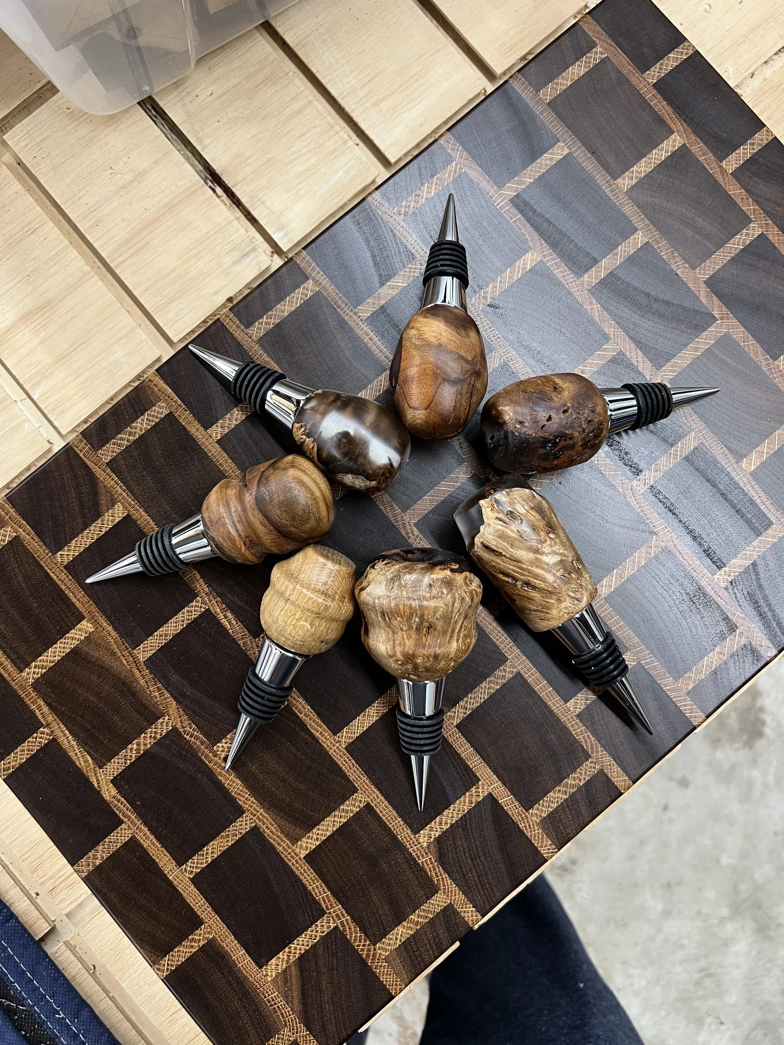 Close-up of a chessboard with wooden and dark tiles, showing a decorative object with large polished stones and metal spikes, on a wooden surface.