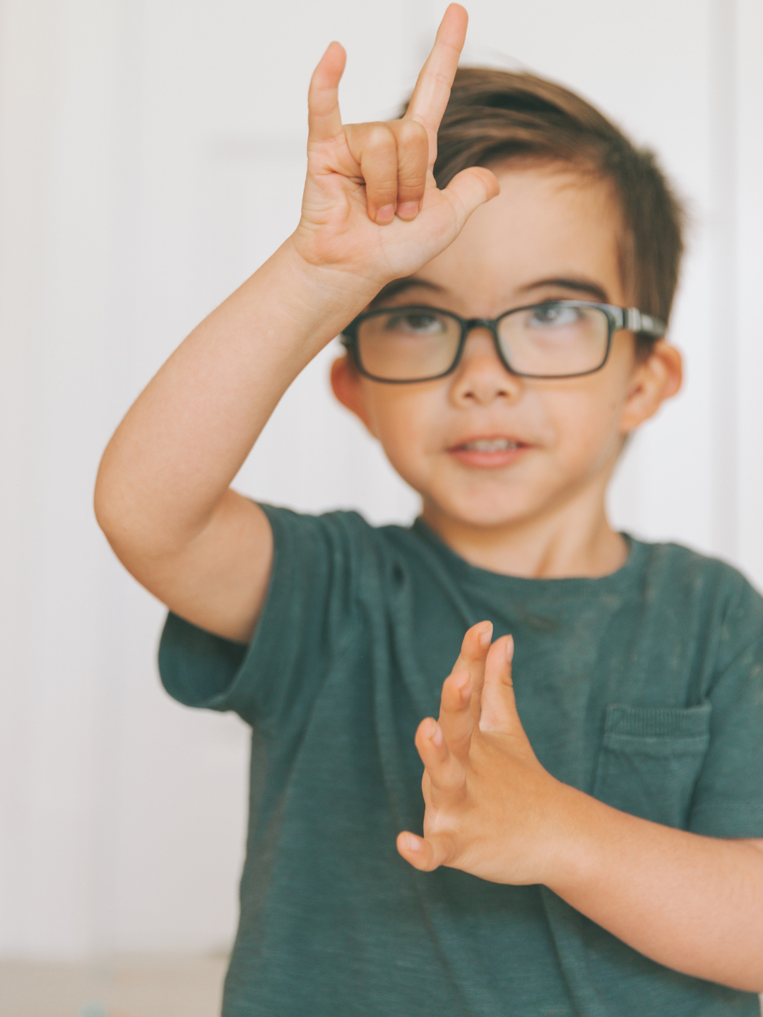 An ABA therapist using visual supports and sign language during a session with a child who is deaf, in a calm and communicative home setting