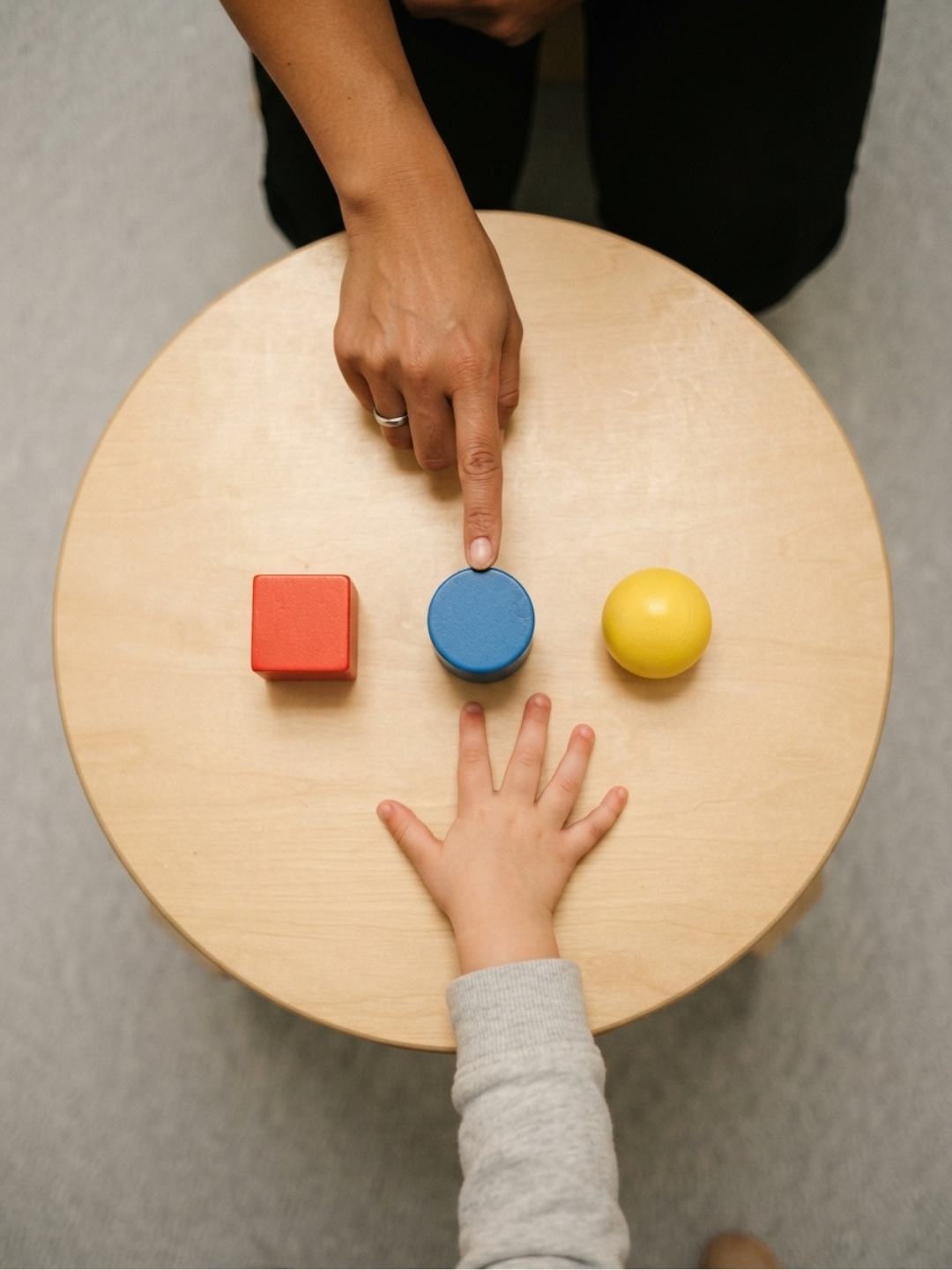 An ABA therapist helping a child develop stimulus control during a structured teaching session, using consistent cues and clear environmental signals