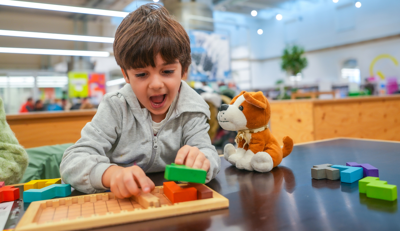 Child organizing school supplies on desk using color coded containers to practice executive function skills like planning and task initiation.