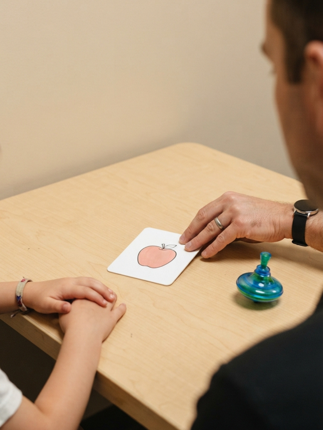An ABA therapist conducting a discrete trial teaching session with a young child at a low table, using clear structured prompts and immediate reinforcement