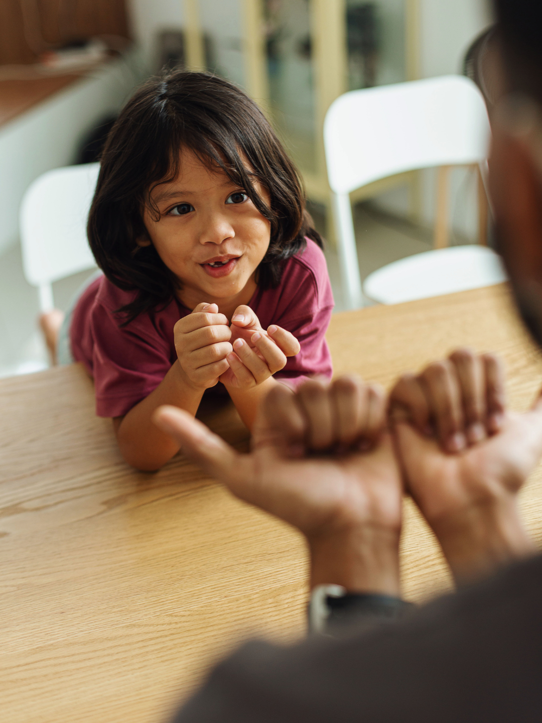 A child in Dubai using sign language as part of their ABA therapy communication programme, supported by a NeuroCore therapist who signs alongside them