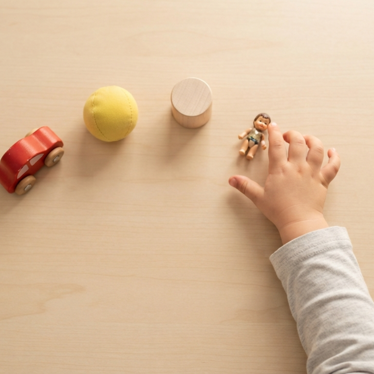 An ABA therapist conducting a preference assessment with a young child, presenting a selection of objects to identify motivating reinforcers