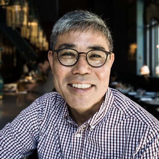 Smiling man with glasses and short gray hair sitting in a restaurant