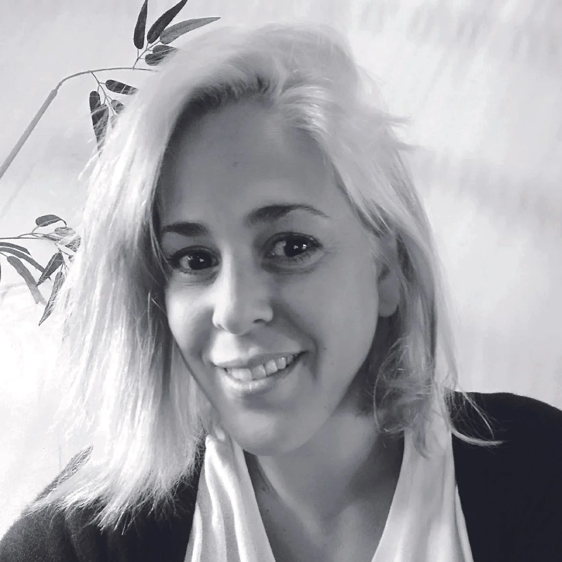 Retrato en blanco y negro de una mujer con cabello rubio y rostro sonriente.