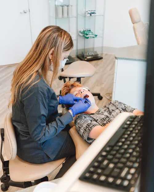Dentist examining a young boy at the dental office.