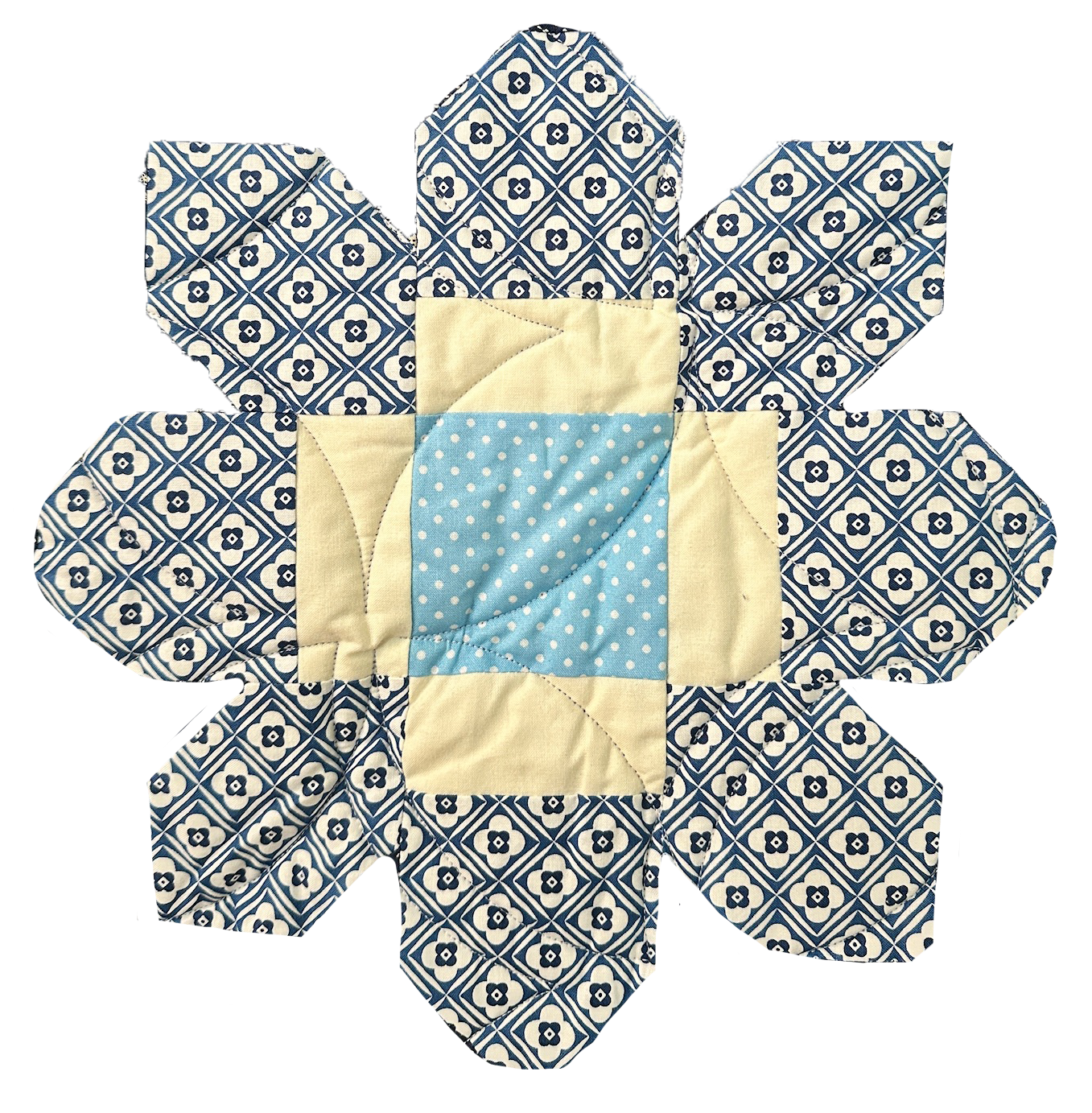 A handmade quilted doll resembling a flower with a blue and white patterned fabric floral design and a central light blue pocket with white polka dots.