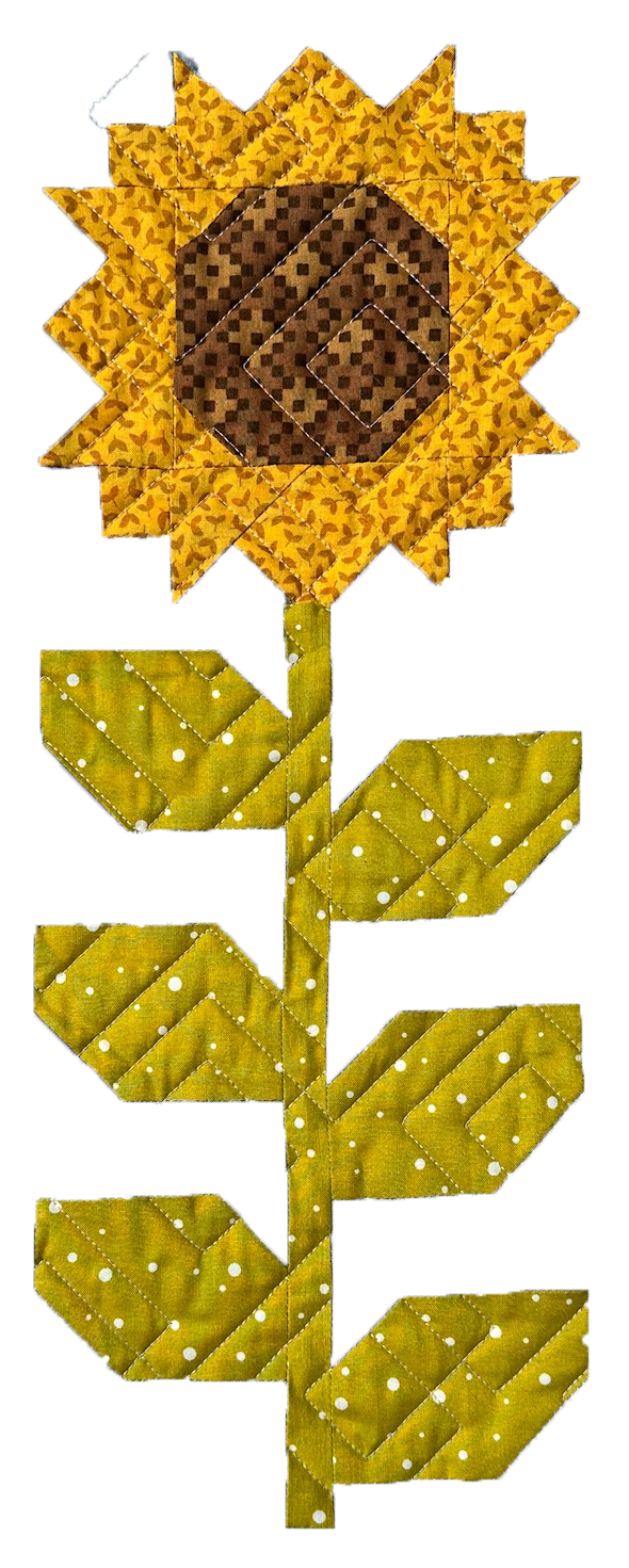 Patchwork quilt arranged in the shape of a sunflower, with yellow petals and a brown center, along with green leaves and stem.