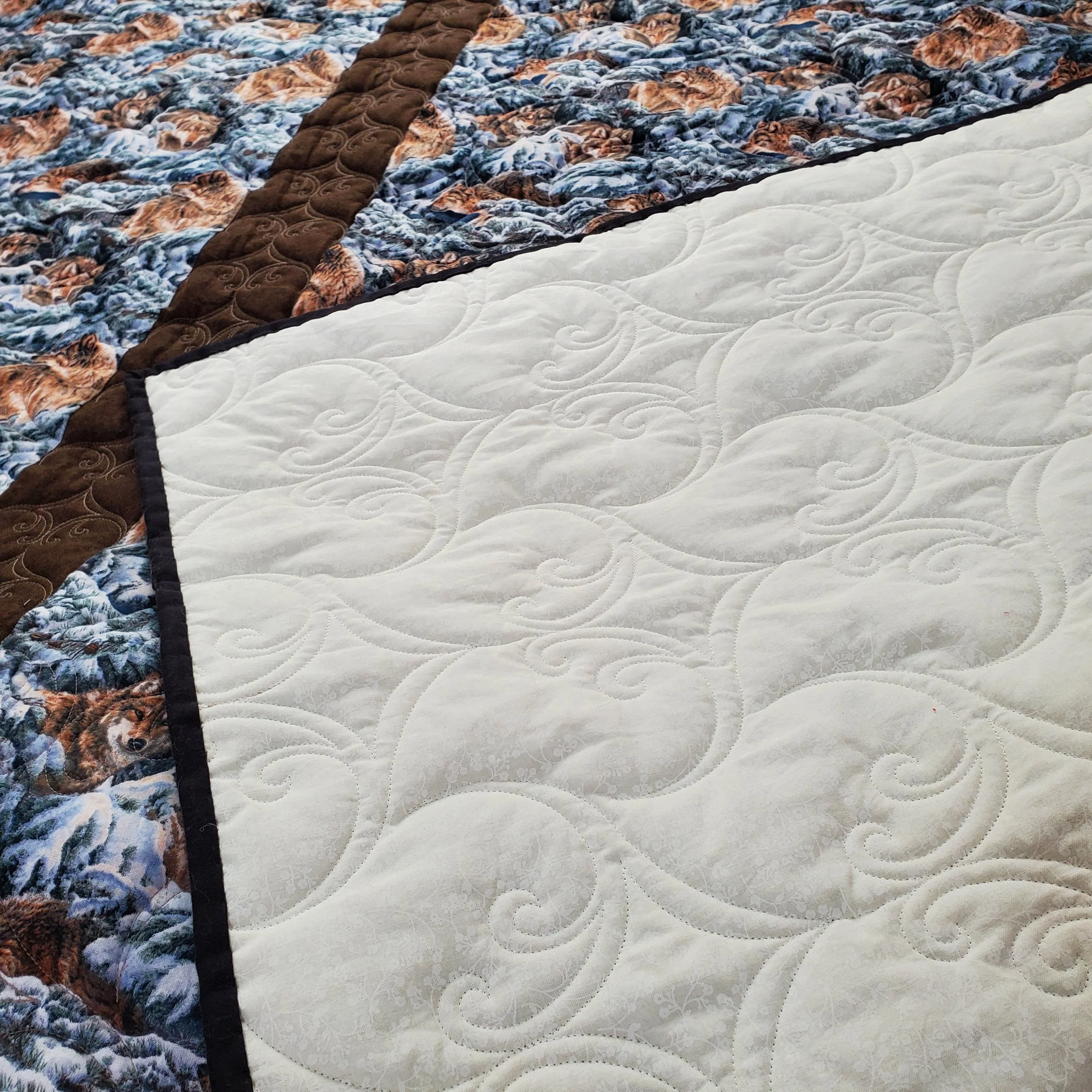 Close-up of two mattresses placed side by side, one with a printed fabric featuring lion images and the other with a plain white fabric.