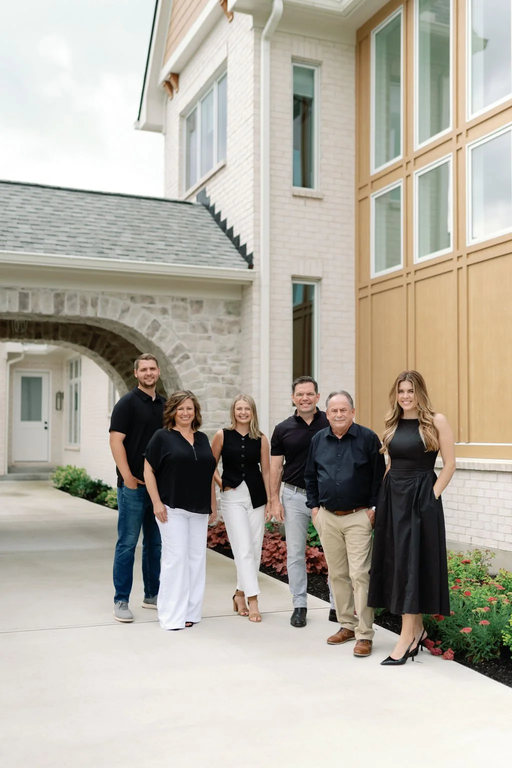 RedKnot Custom Homes team standing outside a custom build home, smiling at the camera.
