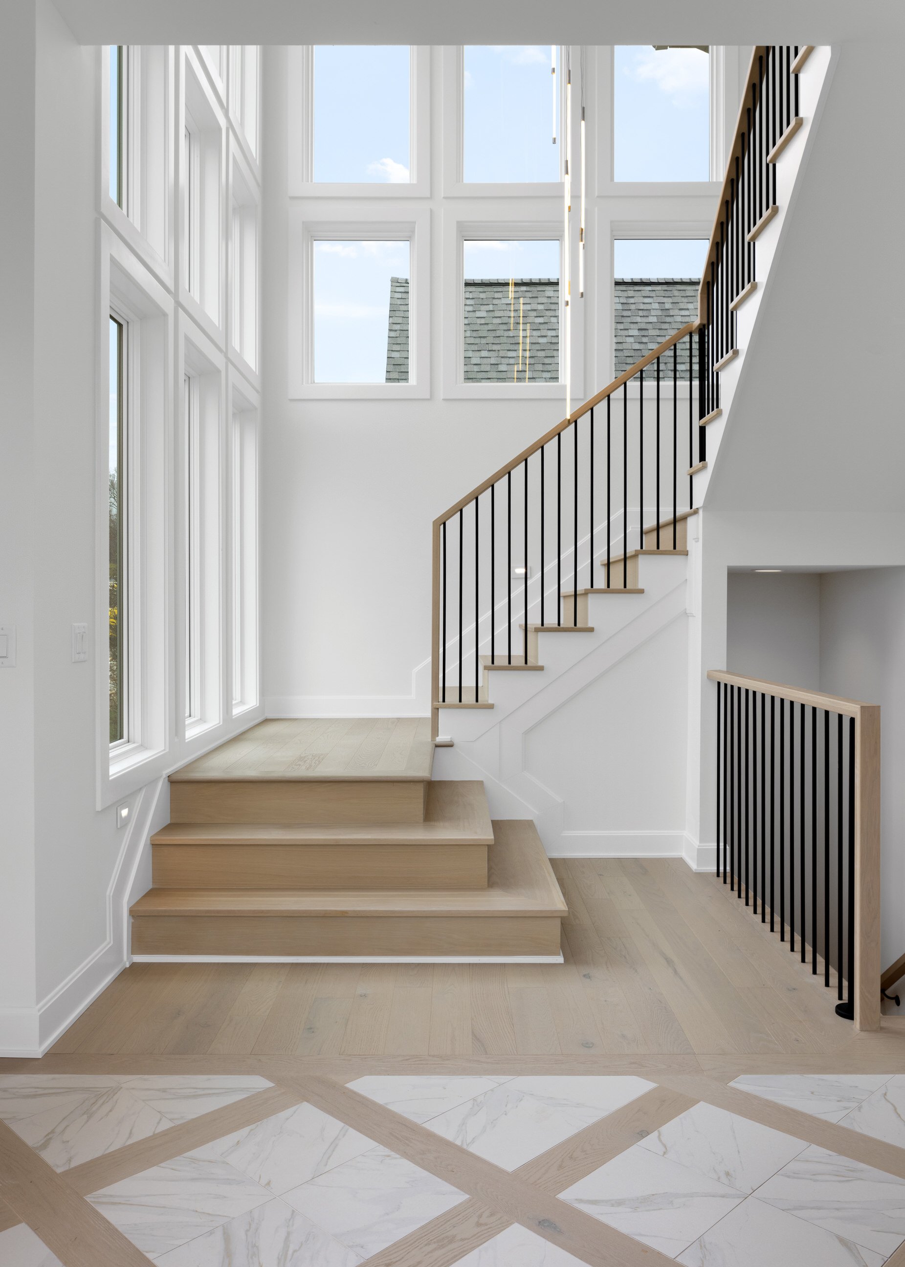 sunlit custom staircase with white oak and beautiful custom detail stairway