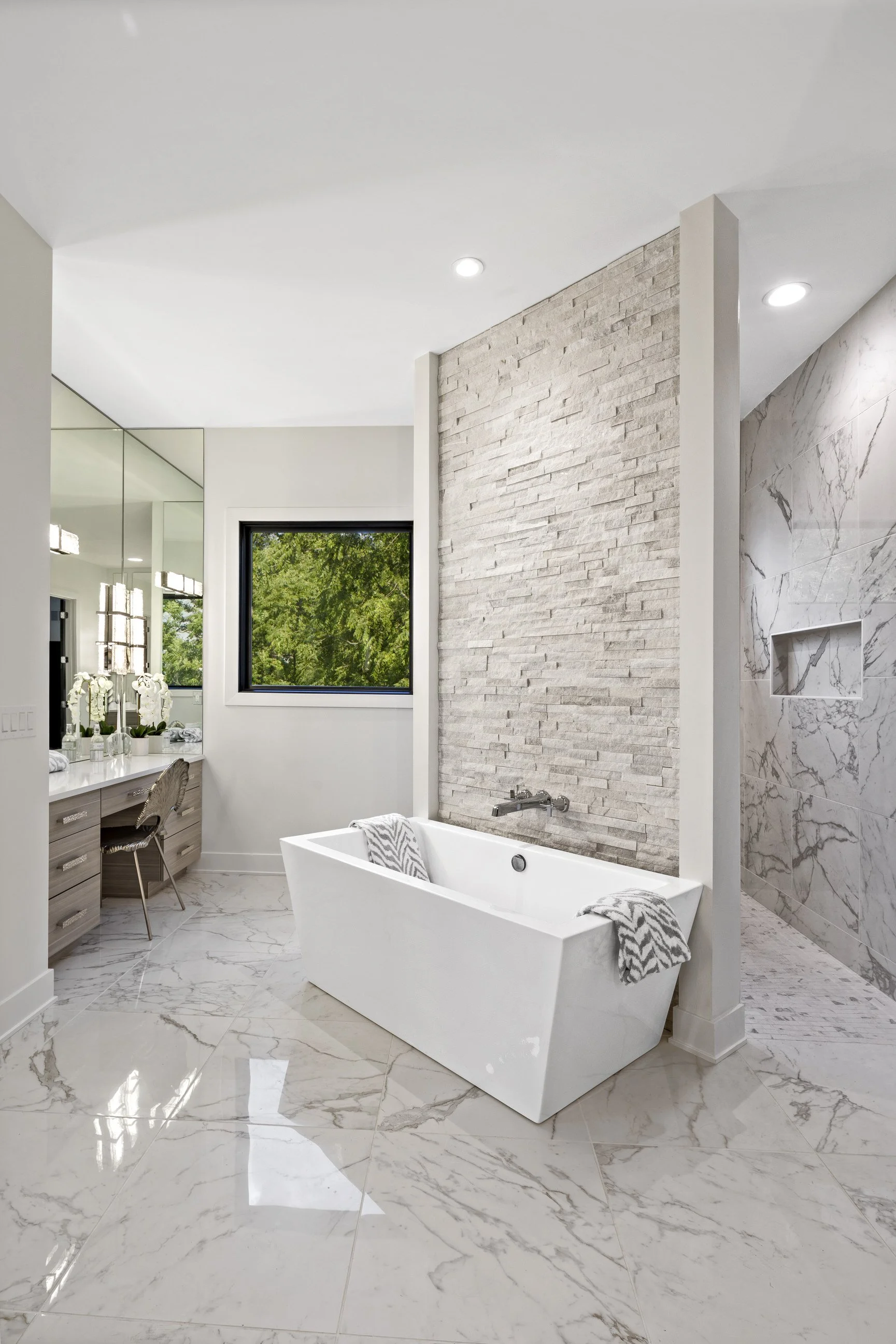 Custom bathroom design with standalone tub, shower and built in vanity with marble tiling