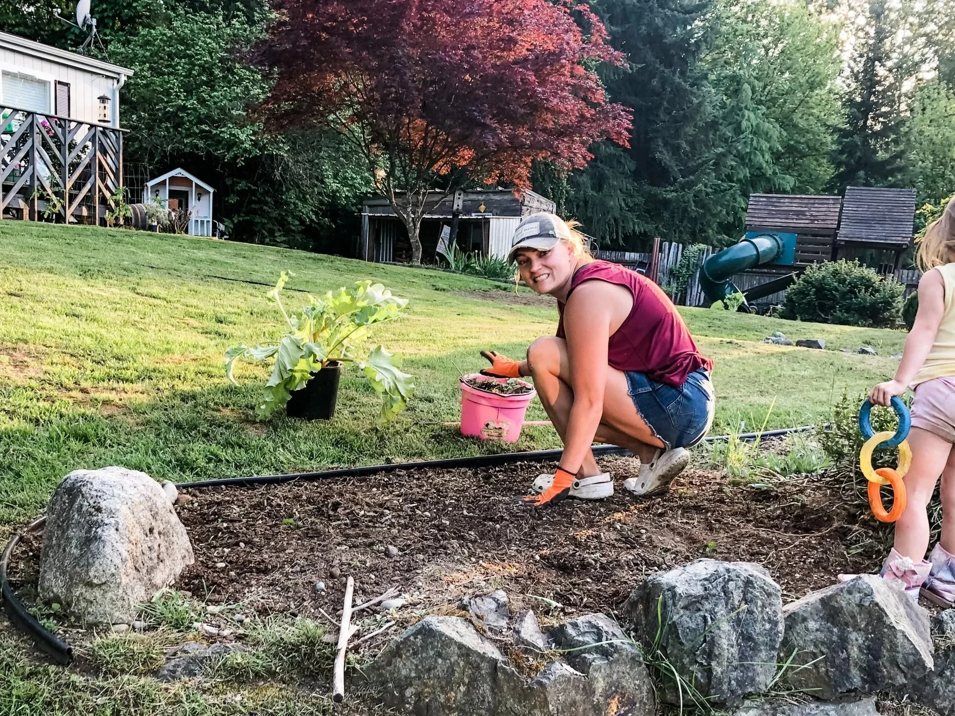 Caitie Henselman gardening with her daughter at their rural home in Eatonville, Washington.