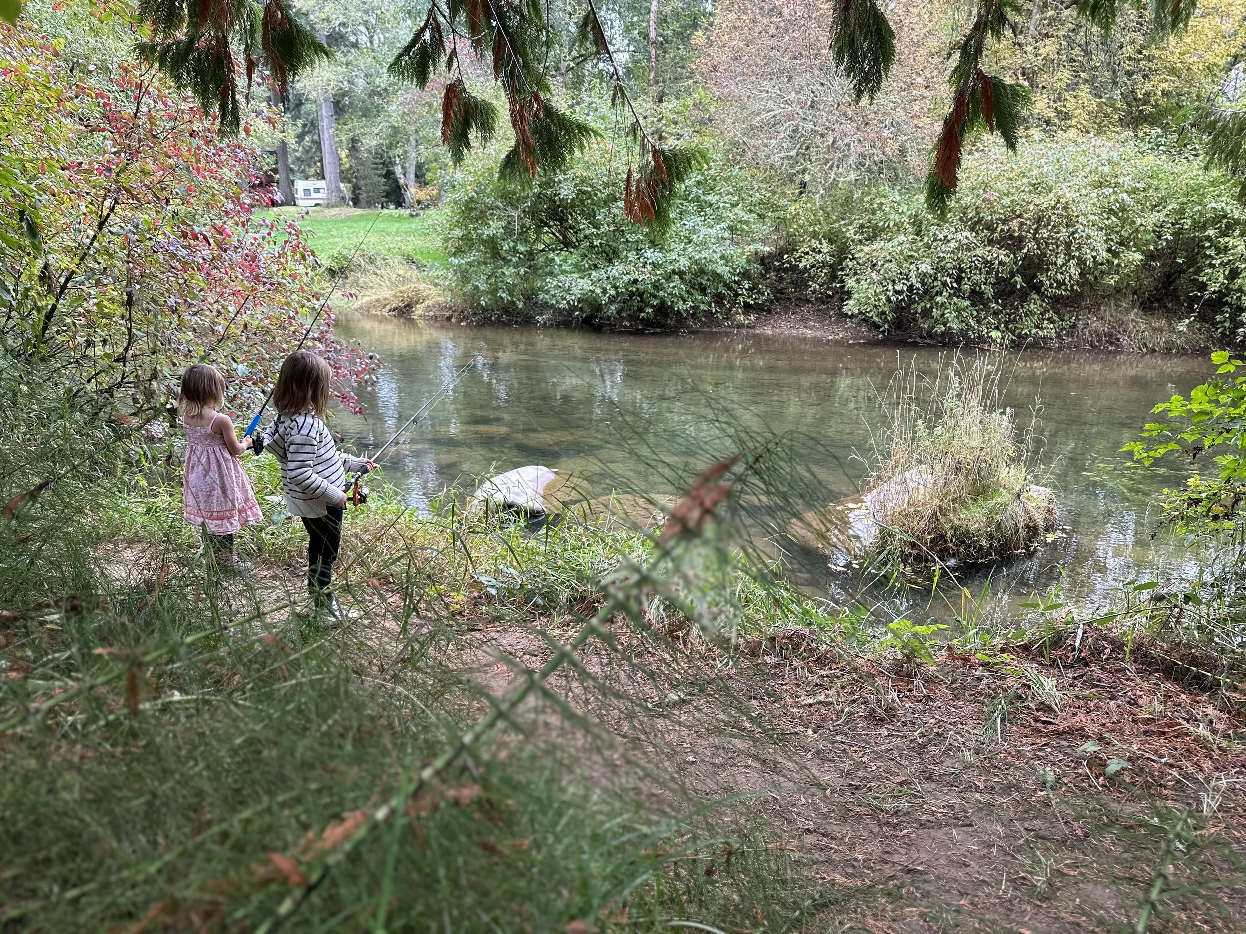 two young girls fishing along a river in Rainier, Washington.