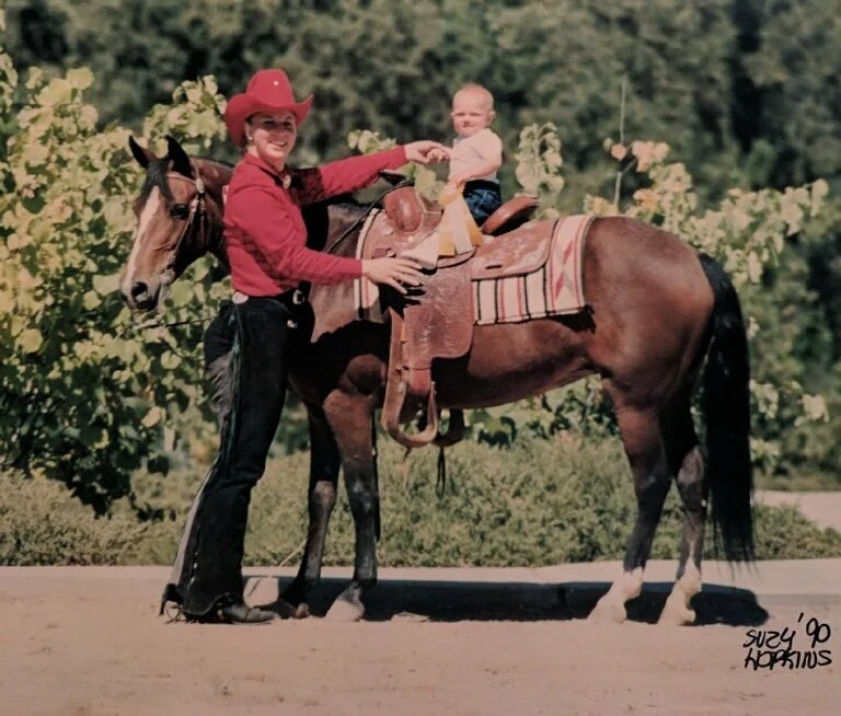 Caitie Henselman at her first horse show in 1990 with her aunt, beginning a lifelong connection to horses and equestrian life.