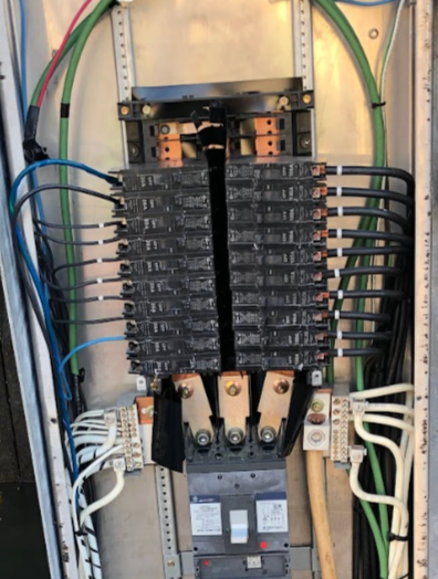 Electrical panel with circuit breakers and wiring.
