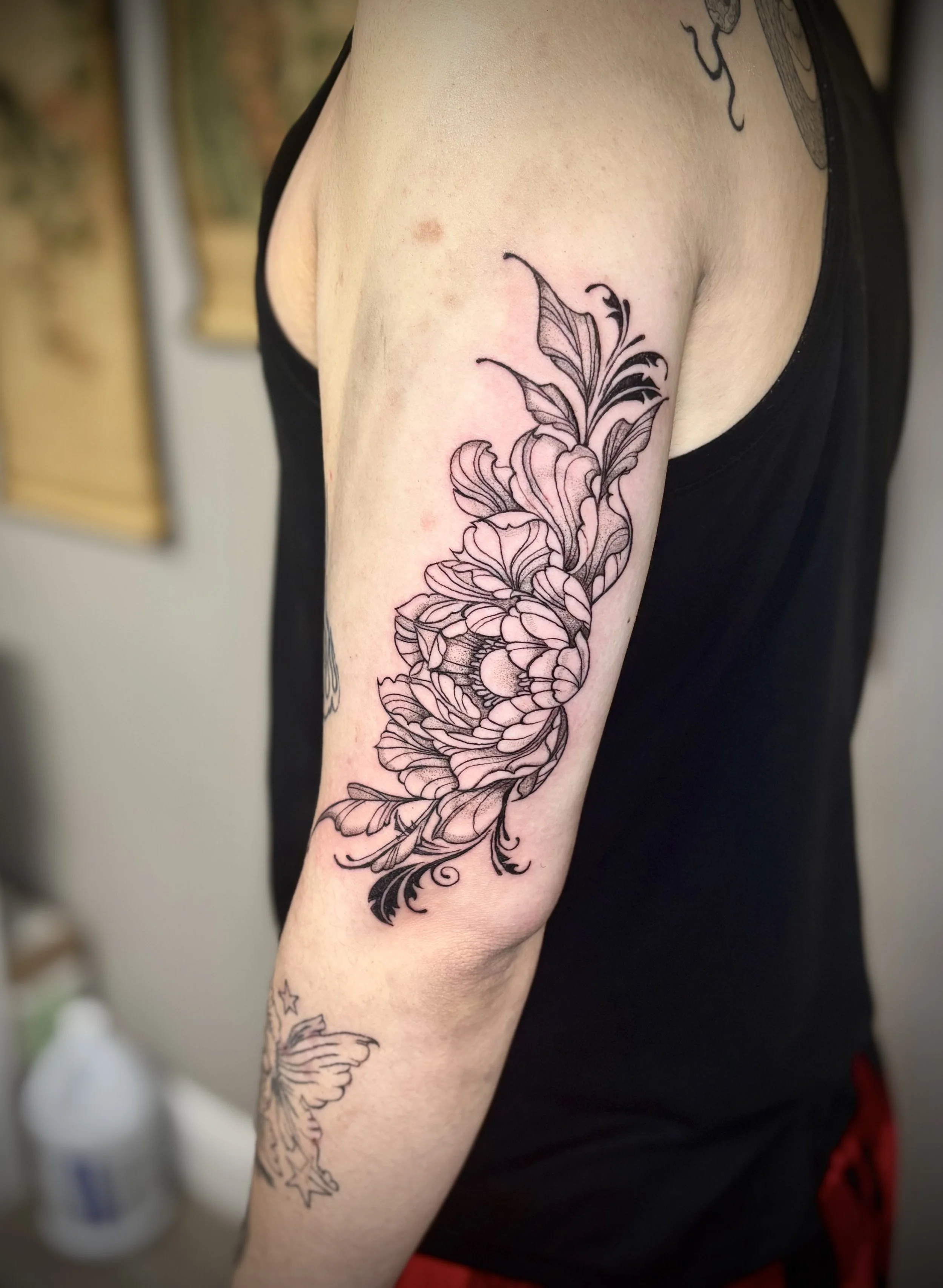 Floral tattoo design. The tattoo features large stylized flowers with detailed line work, extending from the shoulder down the arm. Nix tattoo studio. Tattoos in Silver Spring, MD. Tattoos in the DMV
