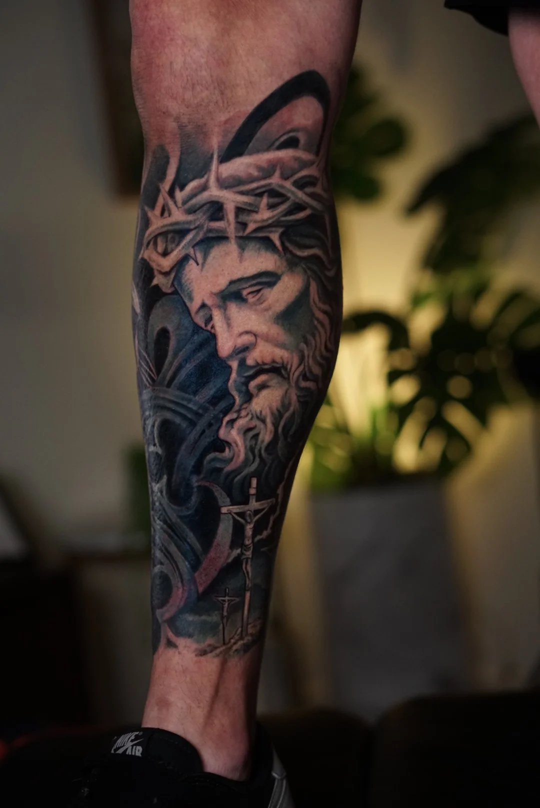 Black-and-gray Jesus Christ tattoo with crown of thorns and cross, created in Charlotte, NC.