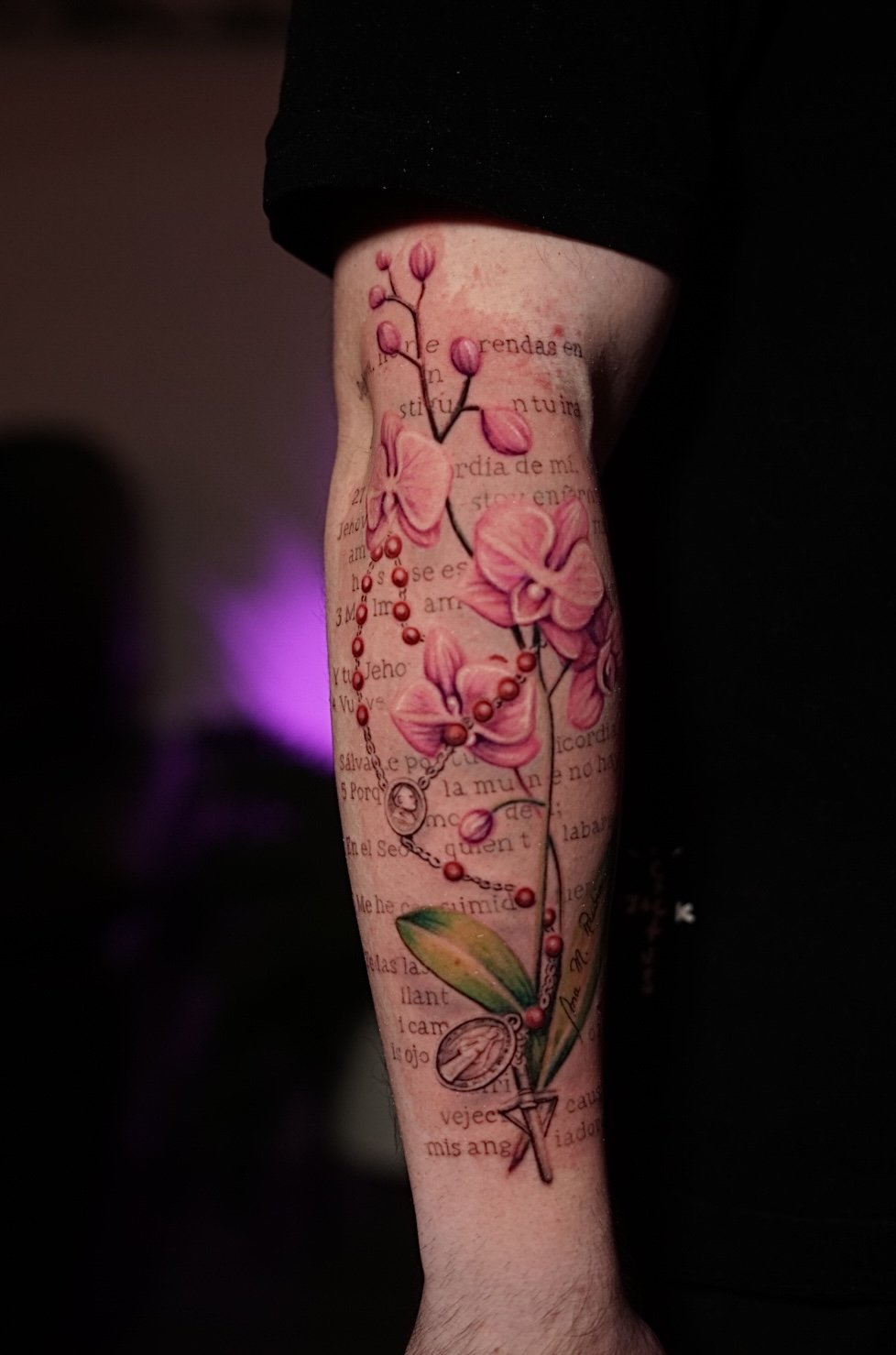 Pink orchid, rosary and pocket-watch forearm tattoo by Luis Dajer.