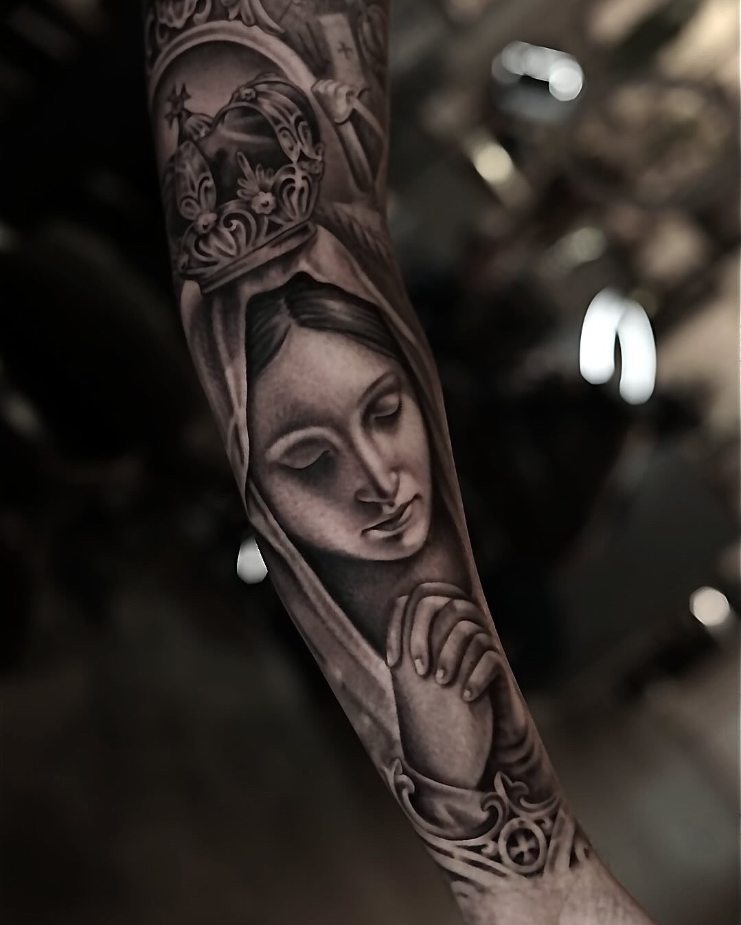 Black-and-gray crowned Virgin Mary arm tattoo by Luis Dajer in Charlotte, NC.