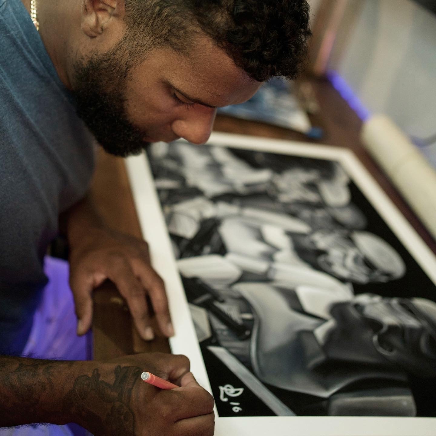 Luis Dajer drawing custom black-and-gray tattoo artwork with a pink pencil.