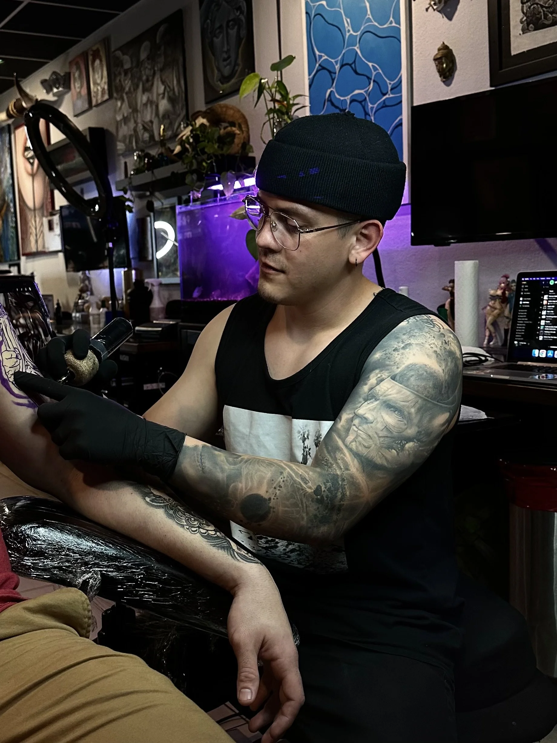 Black-and-gray demon mask and dice tattoo on the arm at Black Craft Tattoo Collective in Charlotte, NC.