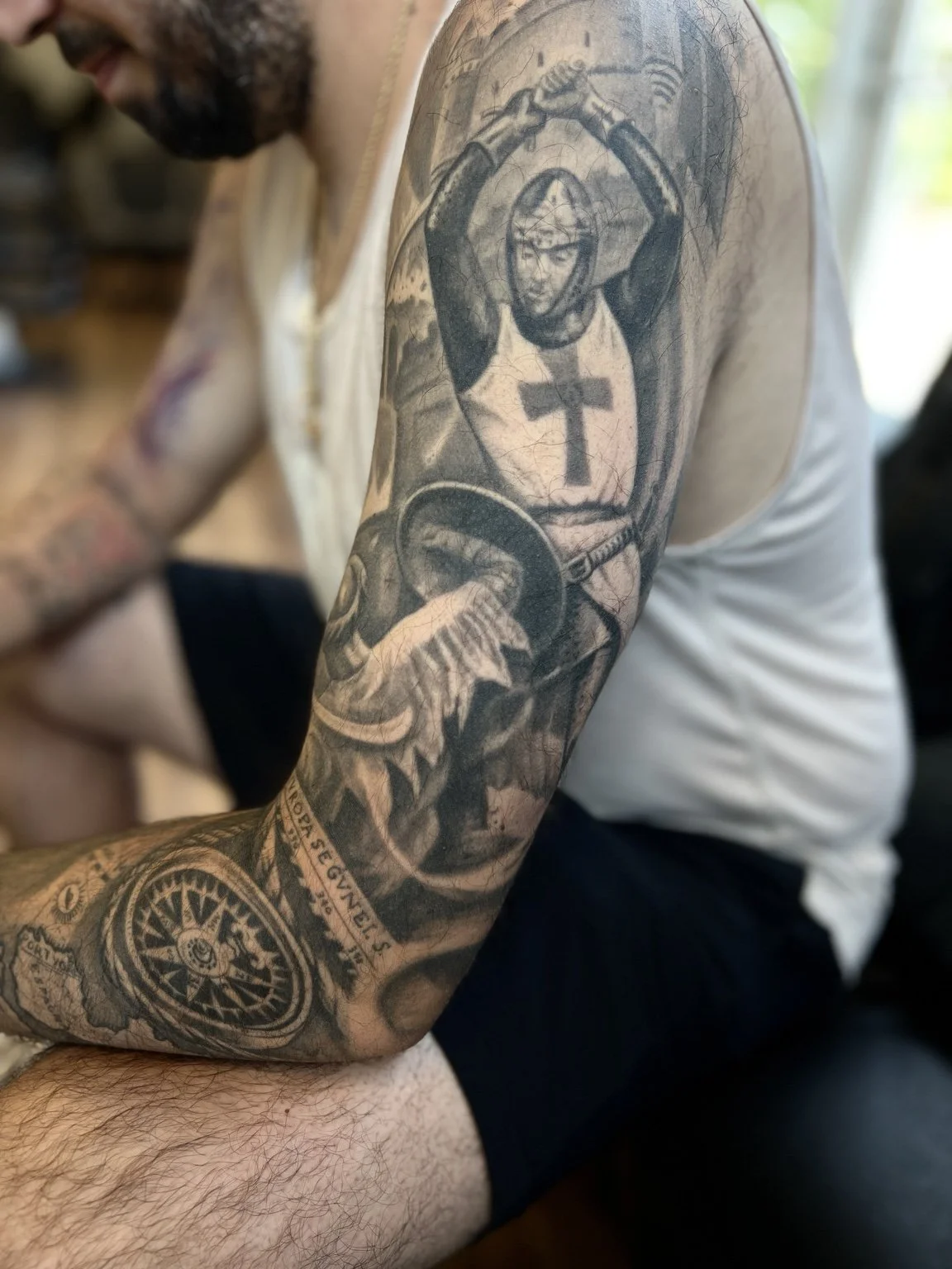 Healed black-and-grey medieval knight and compass sleeve tattoo by Luis Dajer in Charlotte, NC.